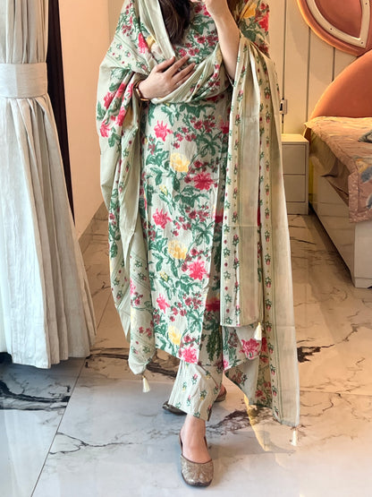 Person wearing a floral dress standing on a wooden floor.