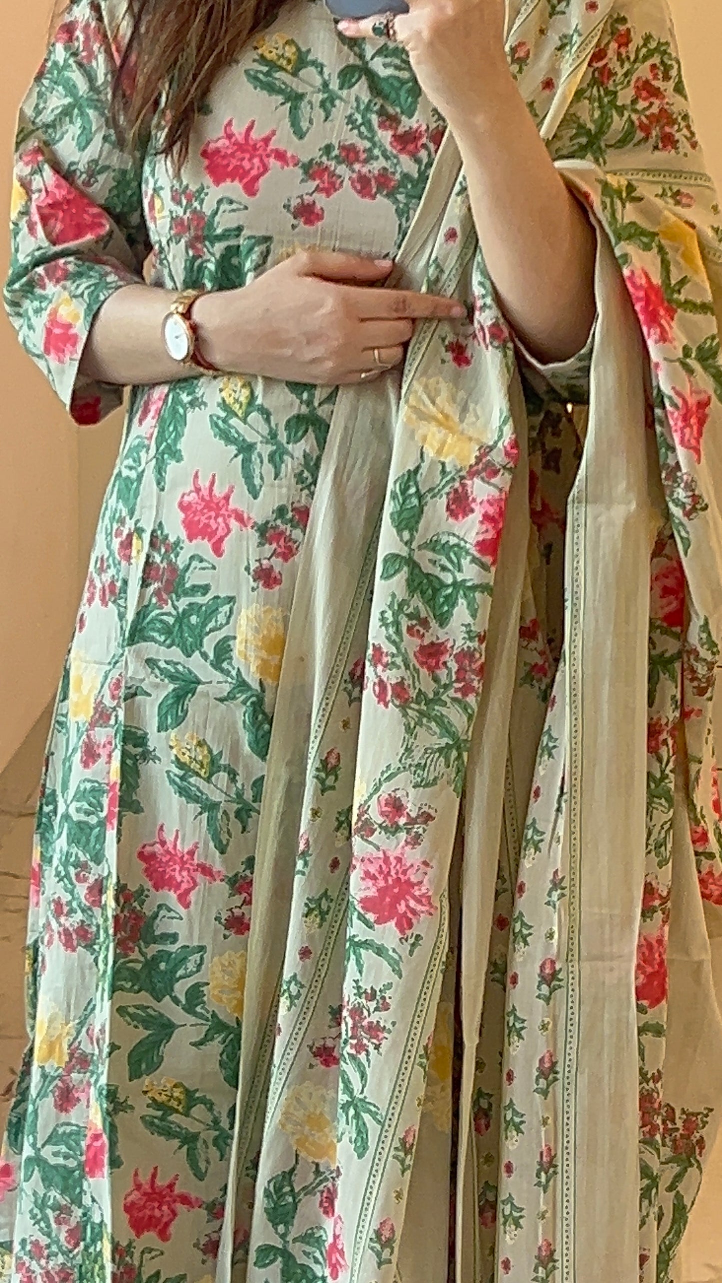 Person wearing a floral dress with a beige dupatta