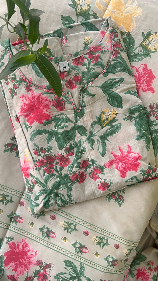 Floral-patterned shirt with pink flowers and green leaves on a floral background
